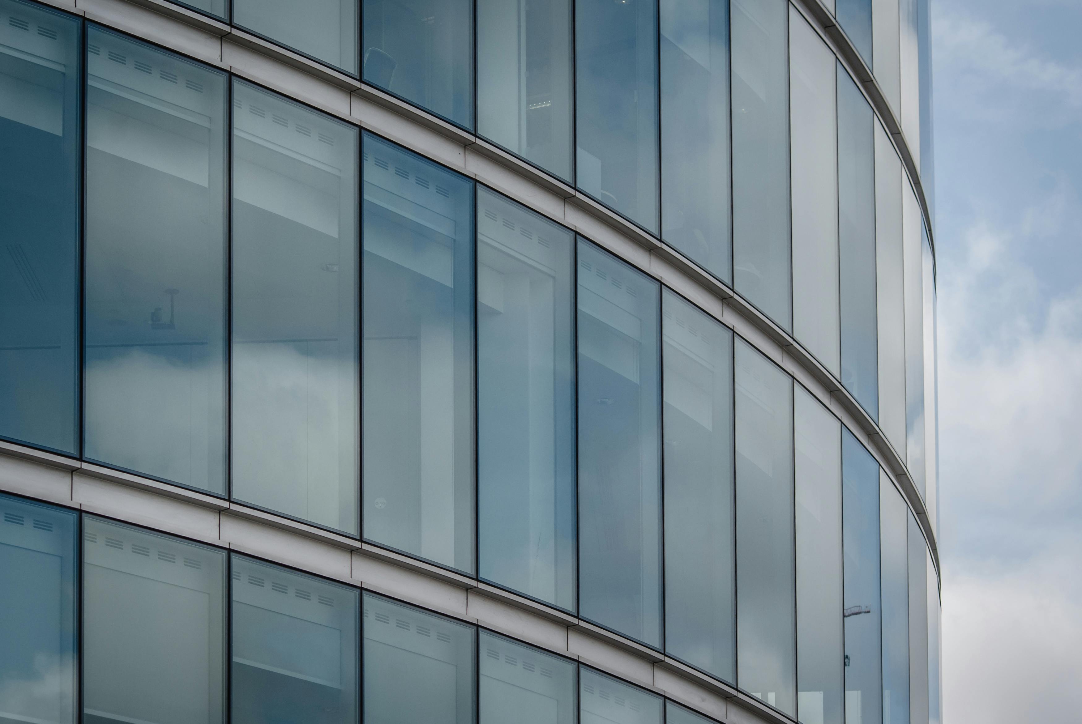 Glass skyscraper facade, reflecting modern architecture and property.